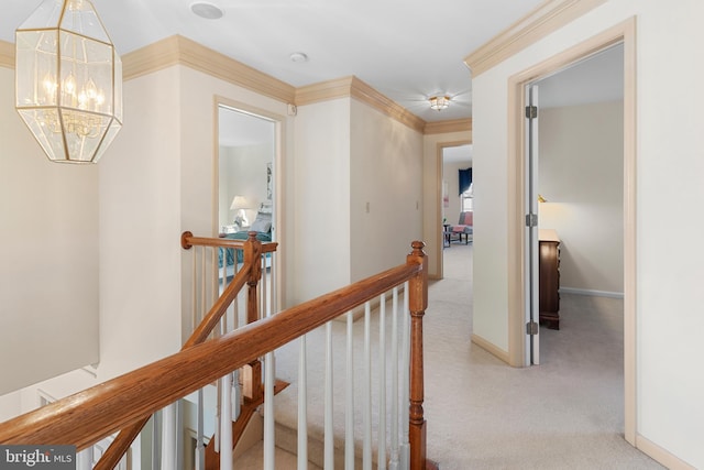 hall featuring crown molding, light colored carpet, and a chandelier