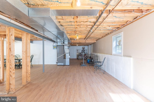 basement featuring heating unit and hardwood / wood-style flooring