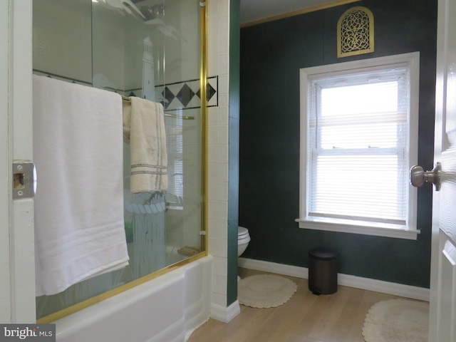 bathroom with toilet, bath / shower combo with glass door, and hardwood / wood-style flooring