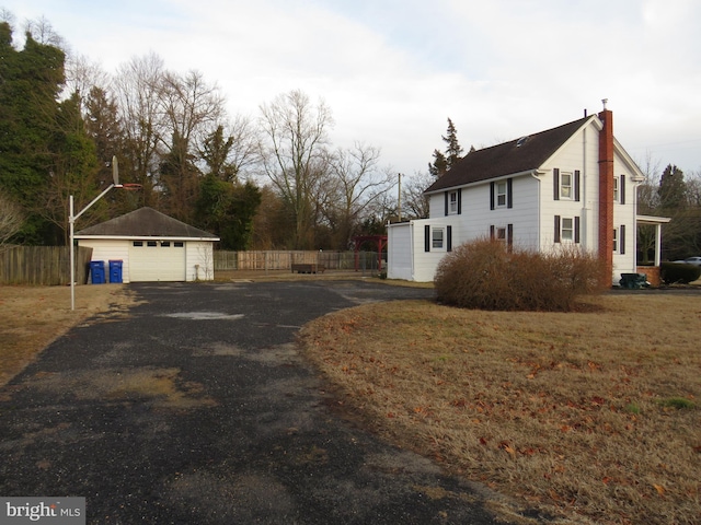 view of home's exterior featuring a garage, an outbuilding, and a lawn