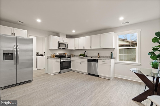 kitchen featuring white cabinets, light wood finished floors, visible vents, and stainless steel appliances