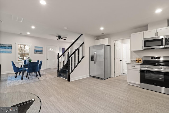 kitchen with white cabinets, light wood-style floors, and stainless steel appliances