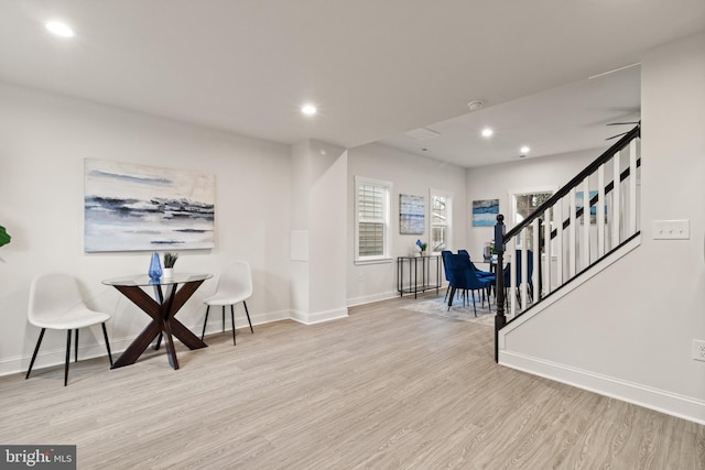 sitting room featuring baseboards, wood finished floors, stairs, and recessed lighting