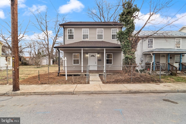 view of front of property featuring a fenced front yard, covered porch, and roof with shingles