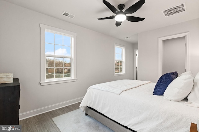 bedroom featuring multiple windows, visible vents, and wood finished floors