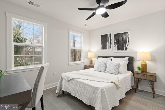 bedroom featuring visible vents, baseboards, and wood finished floors