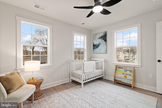 bedroom featuring visible vents, baseboards, and wood finished floors