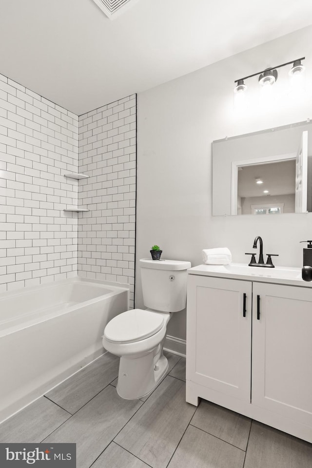 bathroom with washtub / shower combination, vanity, and toilet