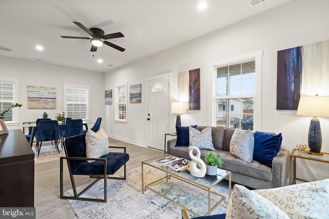 living area with ceiling fan, recessed lighting, wood finished floors, visible vents, and baseboards