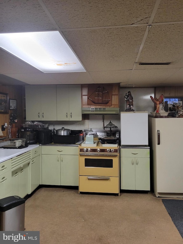 kitchen with fridge, green cabinetry, a drop ceiling, and white range oven