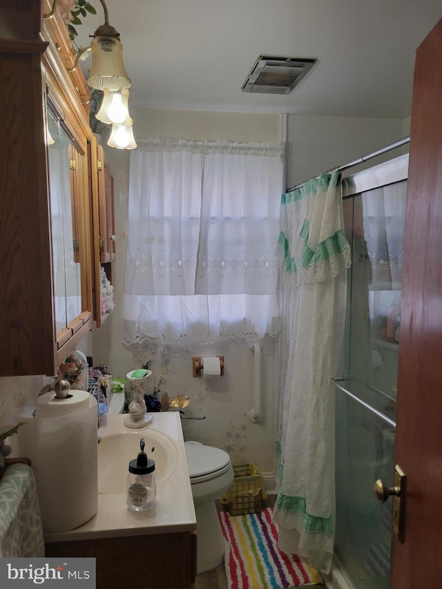 bathroom with vanity, curtained shower, and toilet