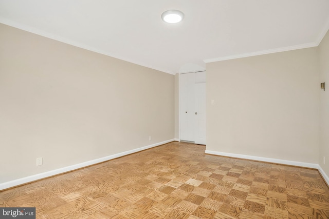 empty room featuring crown molding and light parquet flooring