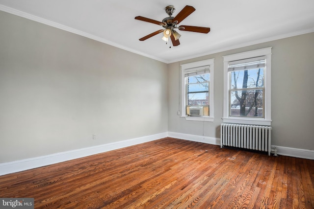 spare room featuring hardwood / wood-style flooring, ornamental molding, radiator heating unit, and ceiling fan