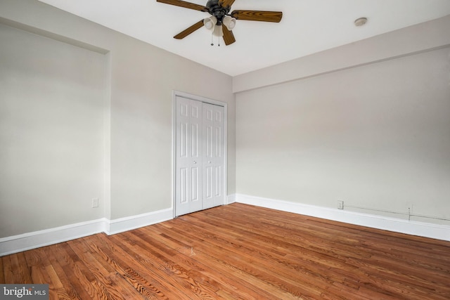 unfurnished bedroom with wood-type flooring, a closet, and ceiling fan