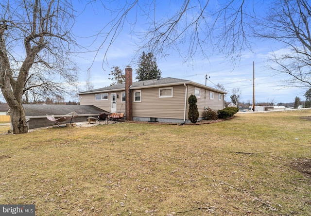 rear view of property featuring a yard