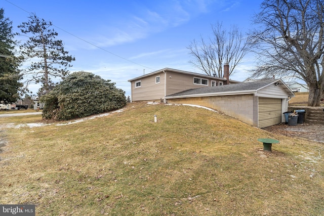 view of property exterior with a yard and a garage