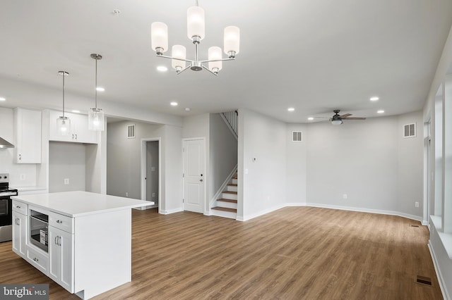 kitchen with white cabinetry, stainless steel appliances, decorative light fixtures, and a center island