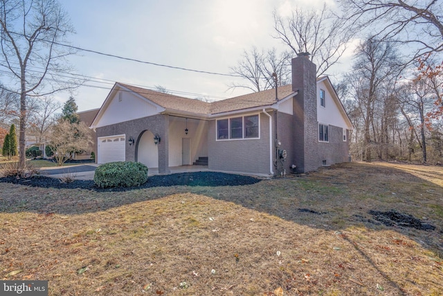 view of front of property featuring a garage and a front lawn