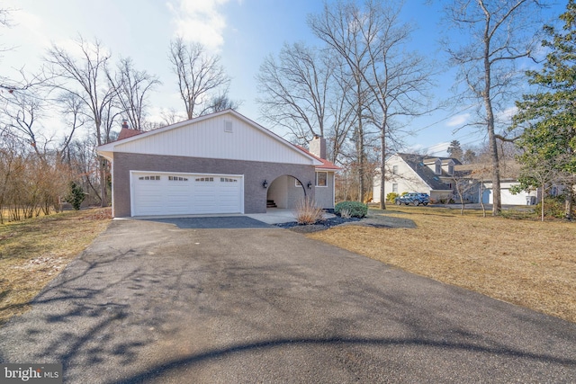 view of side of property with a yard and a garage