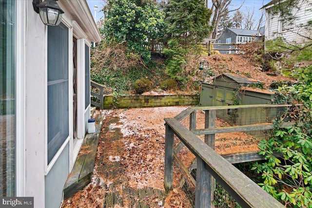 view of yard featuring an outbuilding, a storage unit, and fence