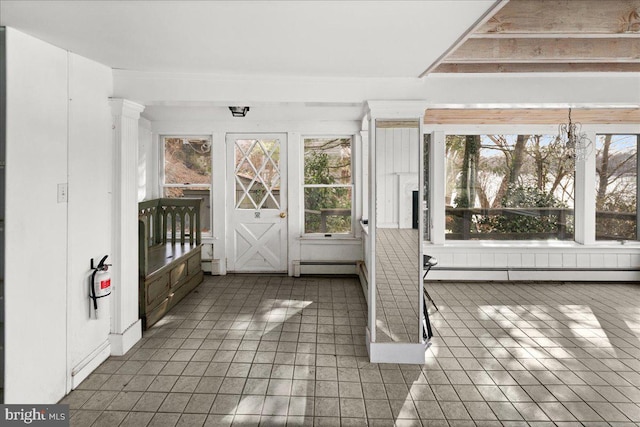 unfurnished sunroom featuring a baseboard heating unit and a notable chandelier