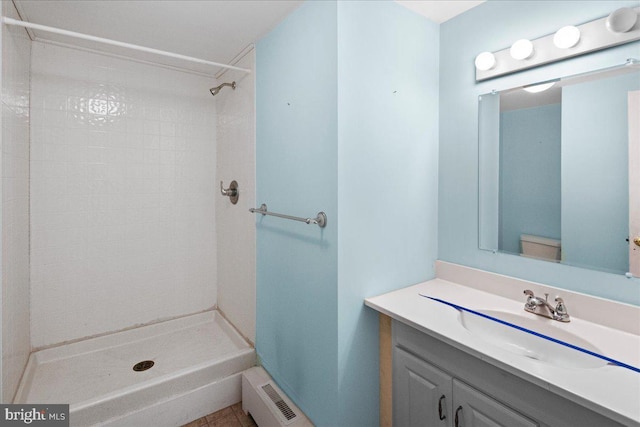 bathroom with visible vents, tiled shower, and vanity