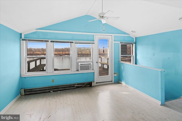 spare room featuring a ceiling fan, wood finished floors, cooling unit, baseboards, and vaulted ceiling