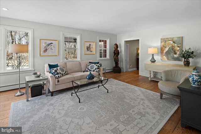 living room featuring baseboards, baseboard heating, and wood finished floors