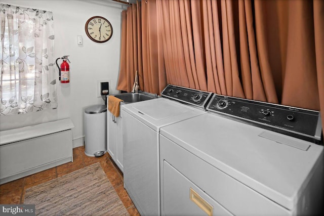 washroom featuring laundry area, washing machine and dryer, and a sink