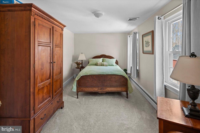 bedroom with a baseboard heating unit, light carpet, visible vents, and baseboards