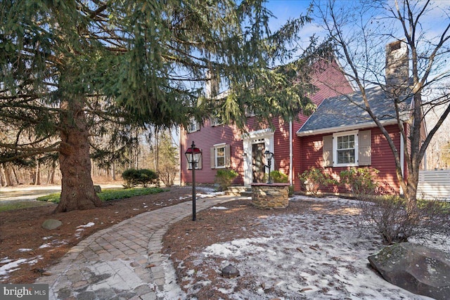 view of front of home with roof with shingles and a chimney