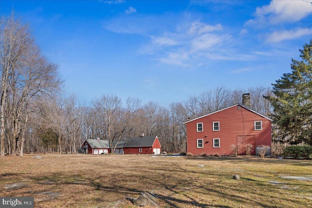 view of side of home with a garage, a yard, and a chimney