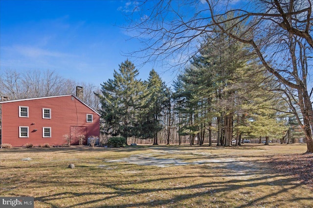 exterior space with a yard and a chimney