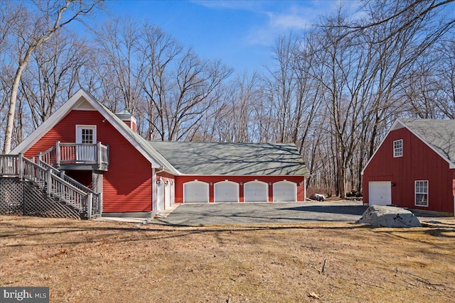 view of outbuilding with gravel driveway and stairs