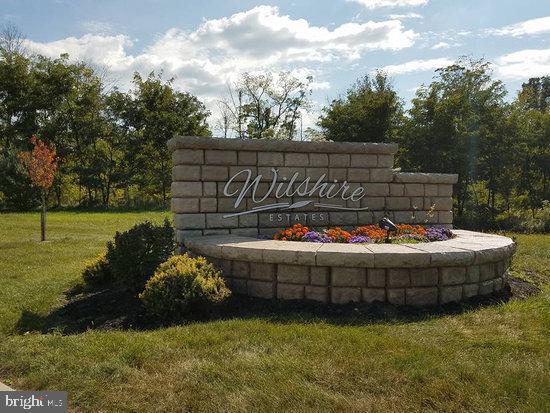 community / neighborhood sign featuring a yard