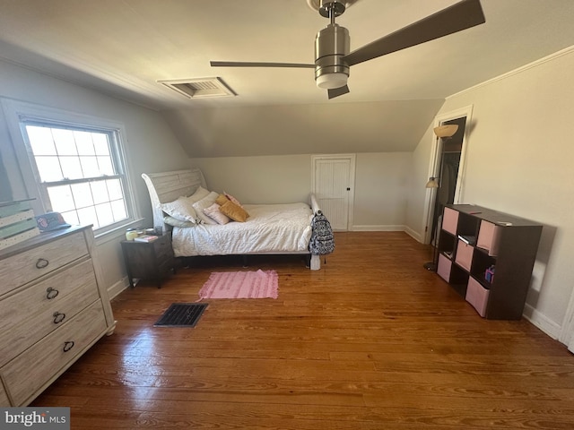 bedroom with lofted ceiling, visible vents, and dark wood finished floors