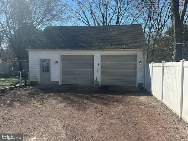 detached garage featuring fence