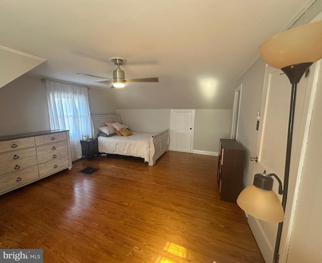 bedroom with vaulted ceiling, visible vents, dark wood finished floors, and ceiling fan