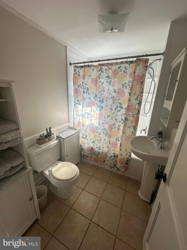 full bathroom with shower / tub combo with curtain, ornamental molding, toilet, and tile patterned floors