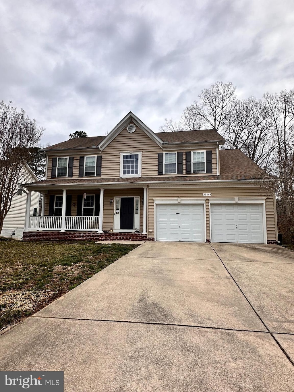 view of front of house featuring a garage, covered porch, and driveway