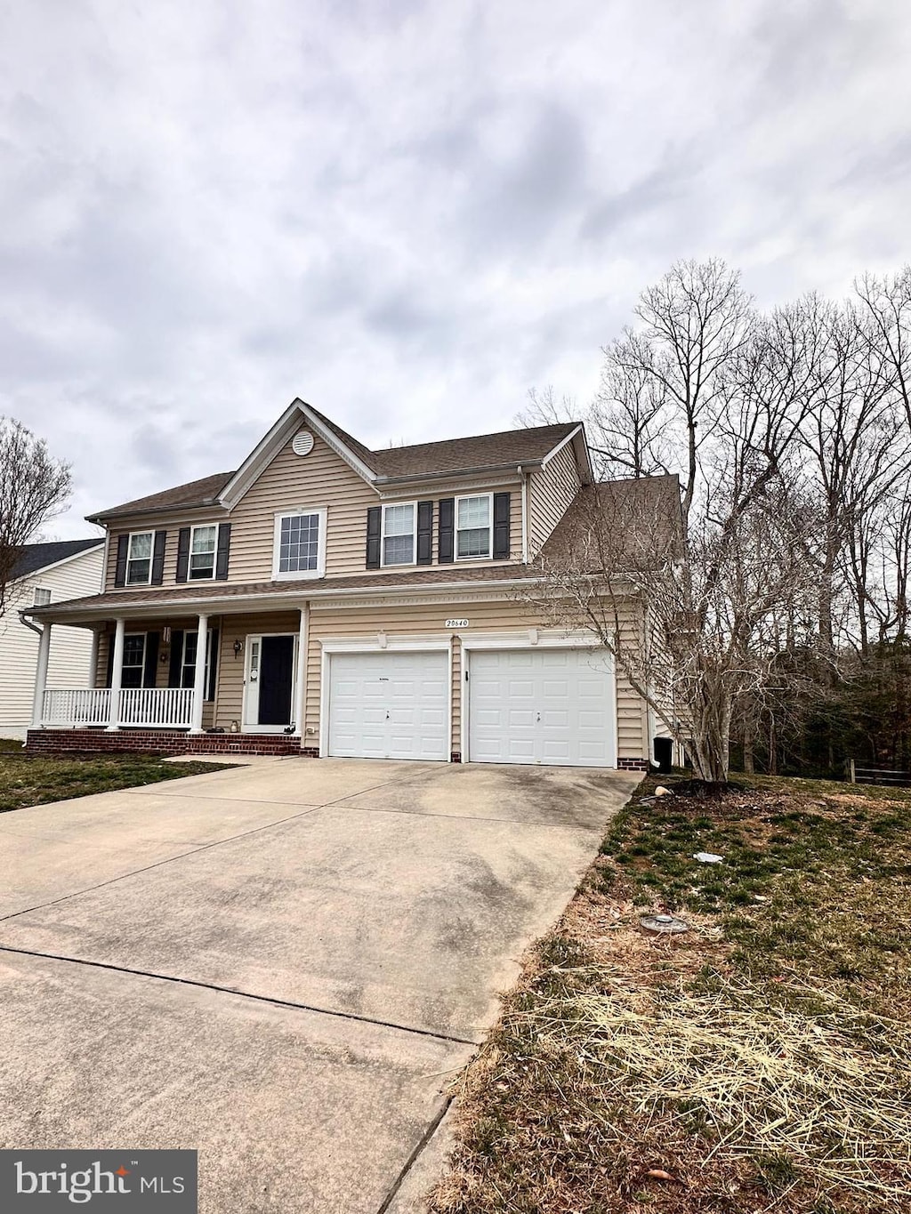 view of front of home with driveway, a porch, and an attached garage