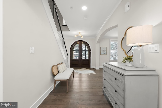 foyer entrance featuring ornamental molding, dark hardwood / wood-style floors, and french doors