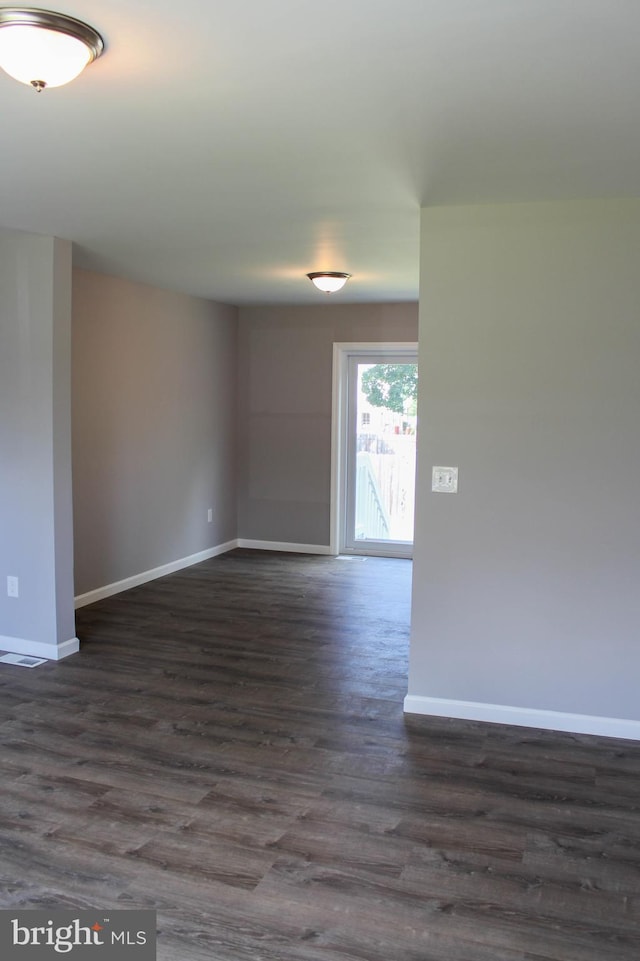 unfurnished room with dark hardwood / wood-style flooring