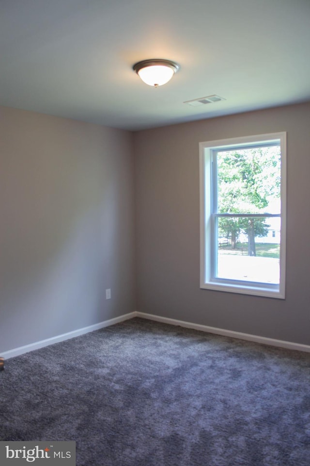 empty room featuring dark colored carpet