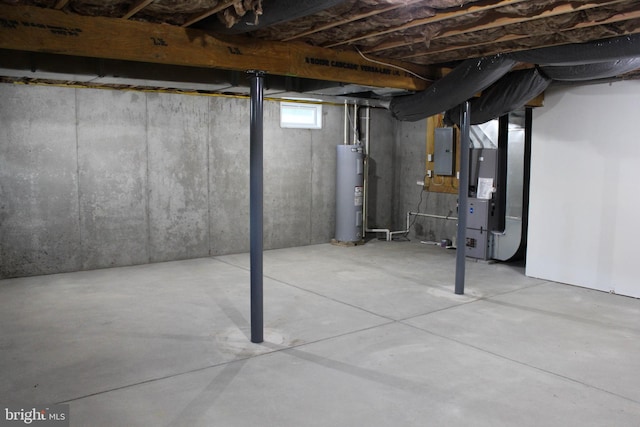 basement featuring electric panel, electric water heater, and heating unit