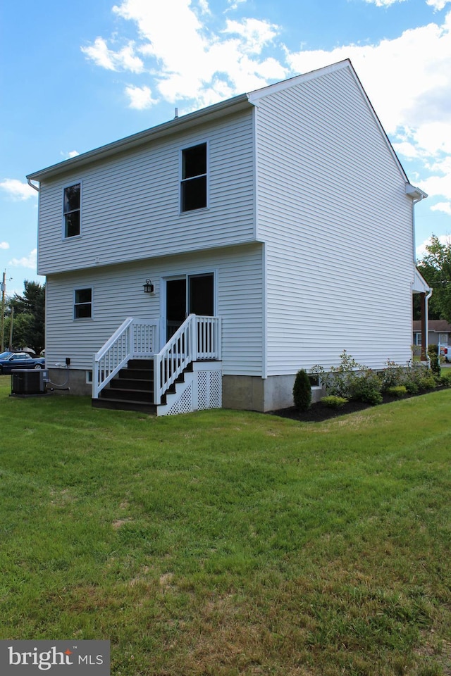 back of house featuring cooling unit and a lawn