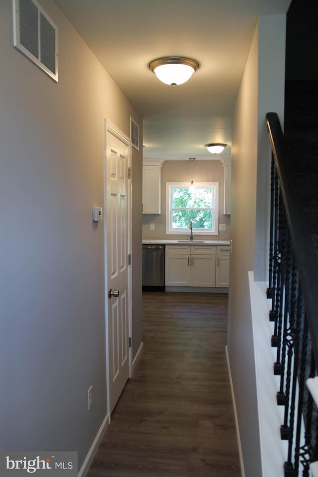 corridor with dark hardwood / wood-style flooring and sink