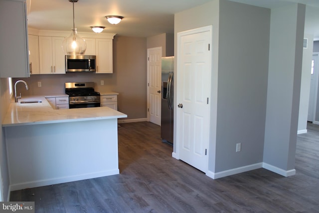 kitchen featuring sink, white cabinetry, hanging light fixtures, appliances with stainless steel finishes, and dark hardwood / wood-style floors