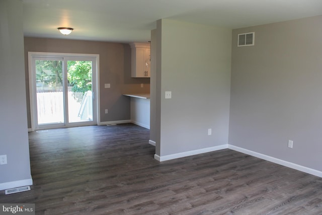 unfurnished living room with dark wood-type flooring