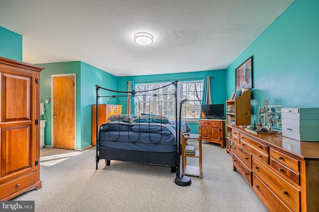 bedroom featuring light carpet and a textured ceiling